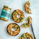 Butter Bike jar of Everything Bagel Peanut Butter with spread onto bagels on a light background