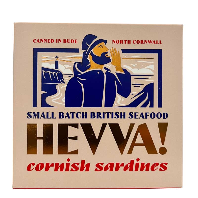 A square 110g box of Hevva! Cornish Sardines, featuring a vintage-style illustration of a sailor shouting towards the sea with a lighthouse in the background. The box is beige with navy blue, red, and gold text and graphics.