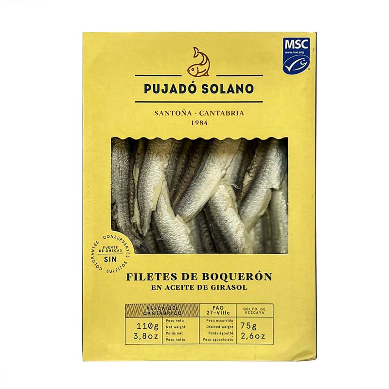 A 110g ack of Pujado Solano Cantabrian Marinated Anchovies - Filetes de Boqueron - showing the silvery anchovies in a window through a yellow branded sleeve.