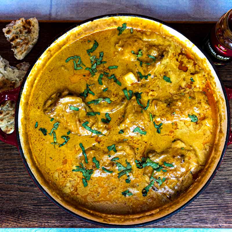 Malaysian Chicken Curry in a wide dish sprinkled with coriander
