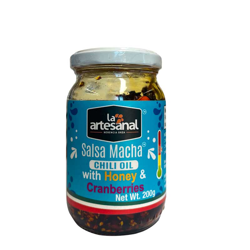 A jar of La Arteanal Mexican Salsa Macha Chilli Oil with honey and cranberries - the jar has an attractive blue label and it's on a white background