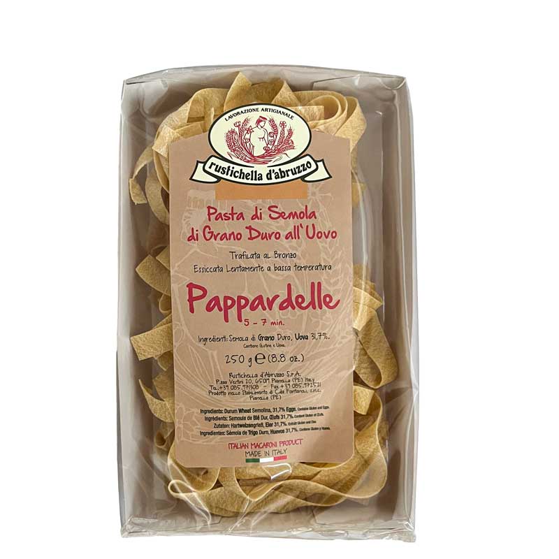 A package of Rustichella d'Abruzzo Dry Egg Pappardelle pasta in a clear plastic tray with a large tan paper label, photographed on a white background.